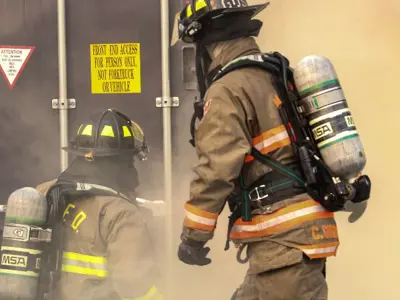 two firefighters breaking in door
