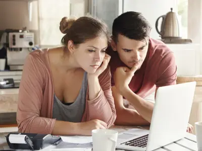 a man and woman looking at a computer