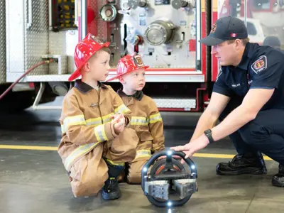 two kids learning from a firefighter